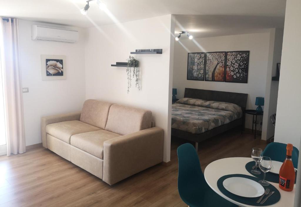a living room with a couch and a table and a bed at HomyHome in Civitavecchia