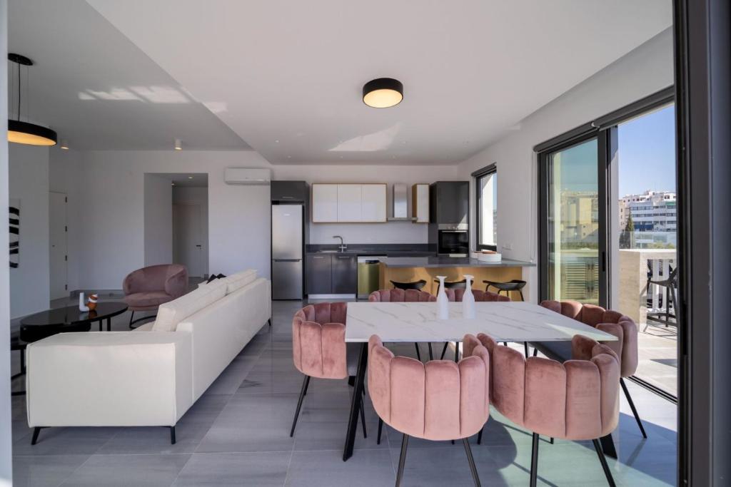 a kitchen and living room with a table and chairs at Premier 403 3 bedroom penthouse in Paphos