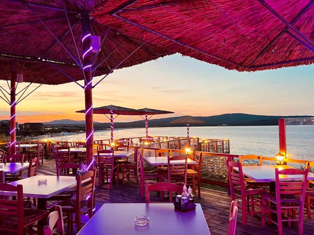 un restaurante en el agua con mesas y sillas en Hotel Nikola, en Primorsko