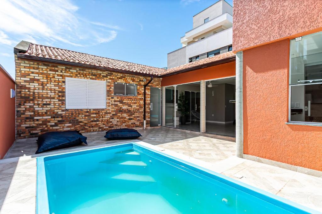 una piscina frente a un edificio en Casa com Piscina a 7 minutos da Praia em Canasvieiras QJ1126, en Florianópolis