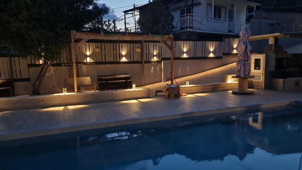 una piscina con luces junto a una casa en Magic View 4U katarina, en Kineta