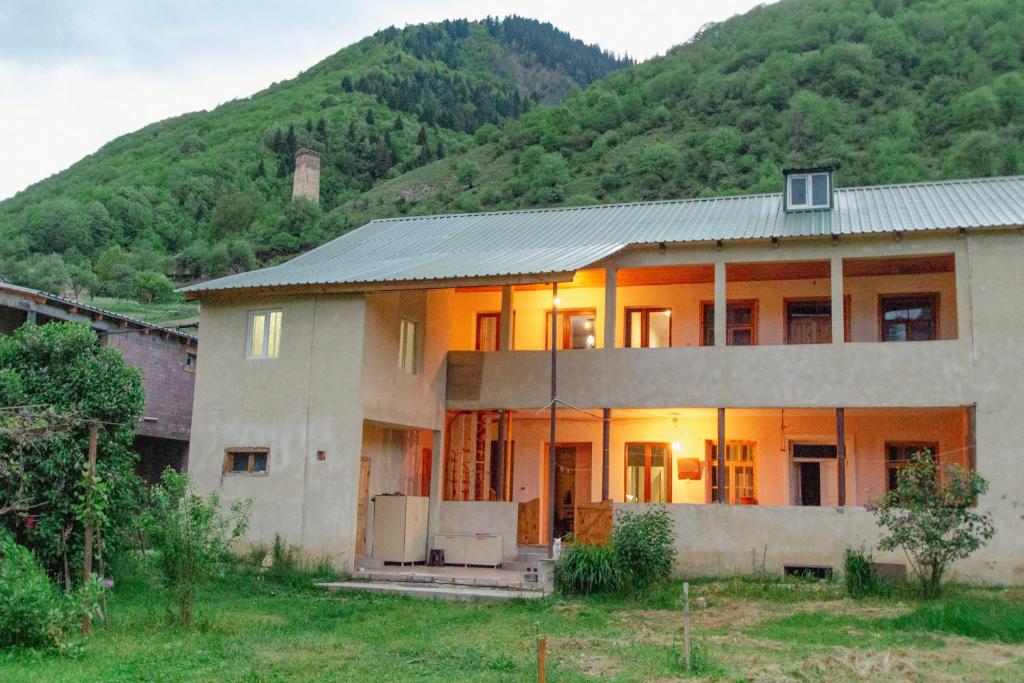 ein Haus mit einem Berg im Hintergrund in der Unterkunft Mishgu Qor in Mestia