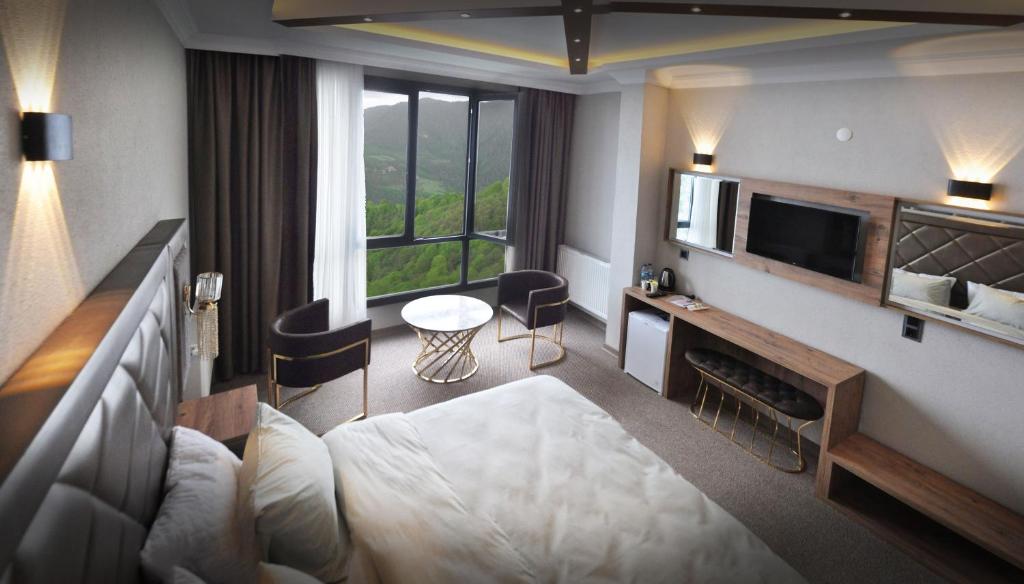 Habitación de hotel con cama y TV en SIRT BUTİK HOTEL, en Akcaabat