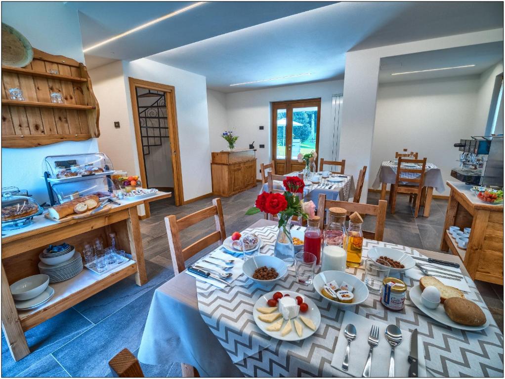 een eetkamer met een tafel met eten erop bij Foresteria Lombarda San Rocco in Colico