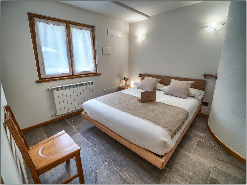 een slaapkamer met een bed met daarop een laptop bij Foresteria Lombarda San Rocco in Colico