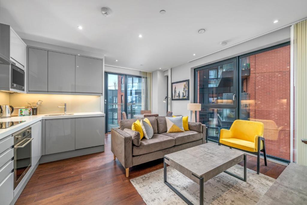 a kitchen and living room with a couch and a table at JOIVY Tasteful flat with balcony in London