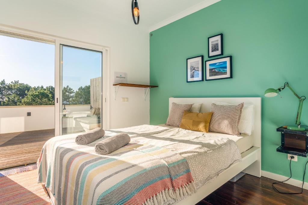 um quarto com uma cama com uma parede azul em Beach House Clerigo - 2 Unique Apartments em Aljezur