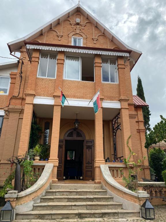 Un bâtiment avec des drapeaux à l'avant dans l'établissement Le Pavillon de l'Emyrne, à Antananarivo