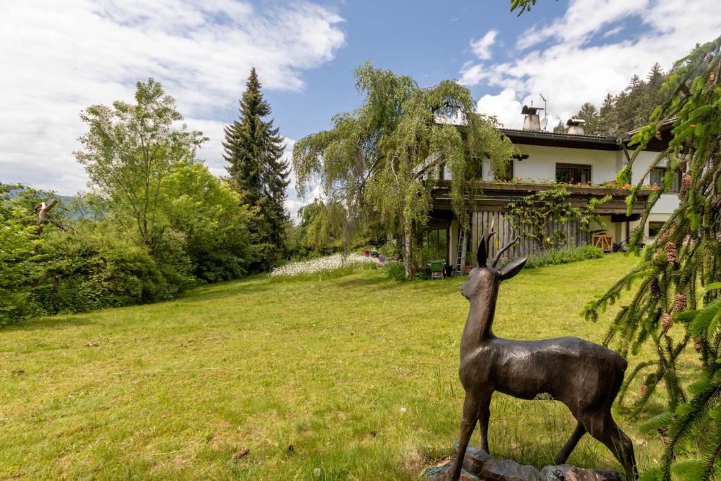 eine Hirschstatue auf einem Feld vor einem Haus in der Unterkunft Chalet Luis in Pfalzen