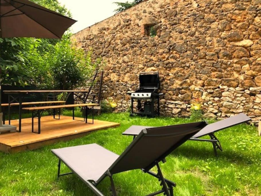 een achtertuin met een grill en een tafel en stoelen bij Joli T2 Jardin, entre mer/verdon in Salernes