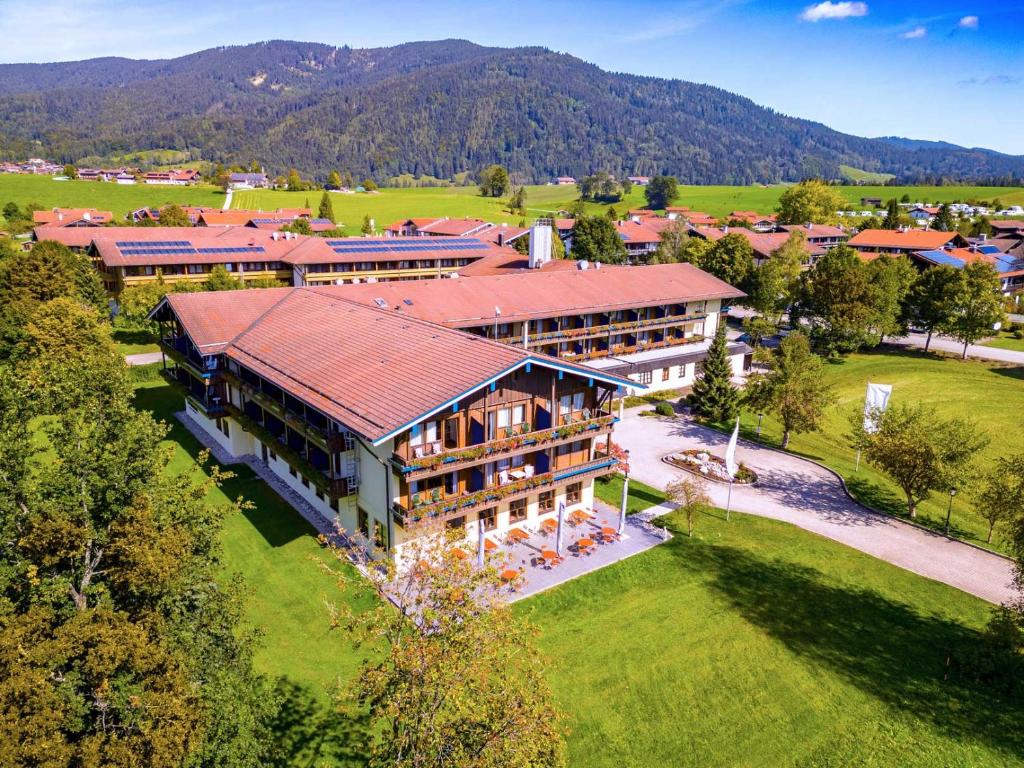 an aerial view of a large building with a mountain in the background at Das Wiesgauer - Alpenhotel Inzell in Inzell