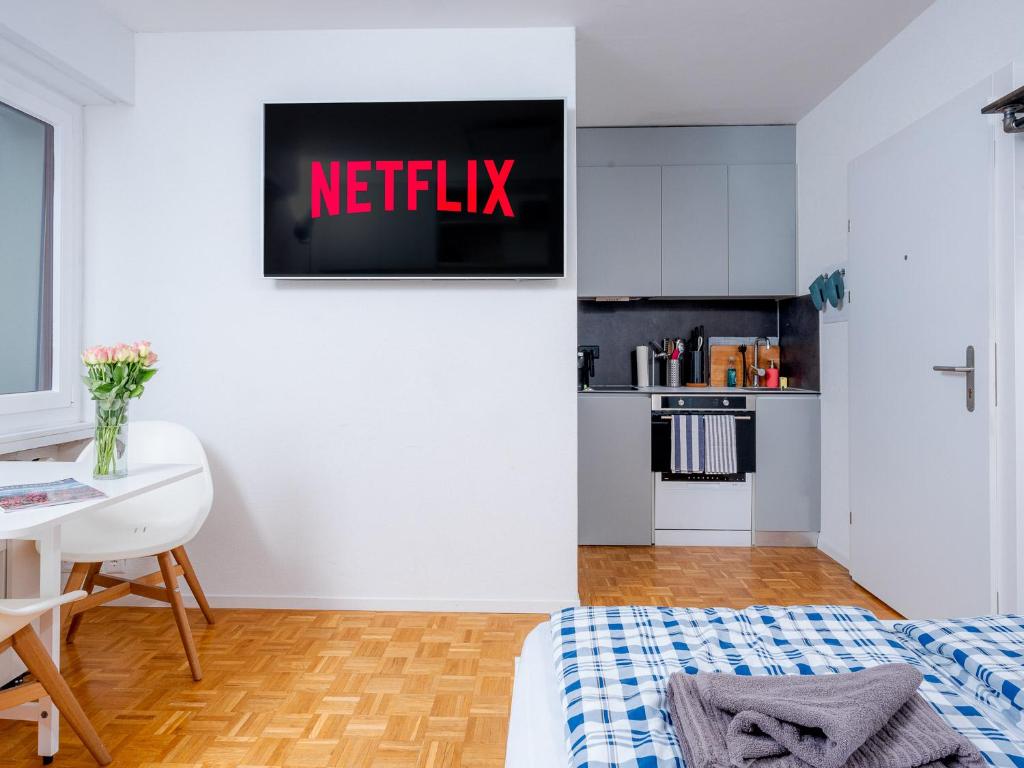 1 dormitorio con 1 cama y un cartel de netflix en la pared en Cozy modern Studio super location feels like home, en Crans-Montana