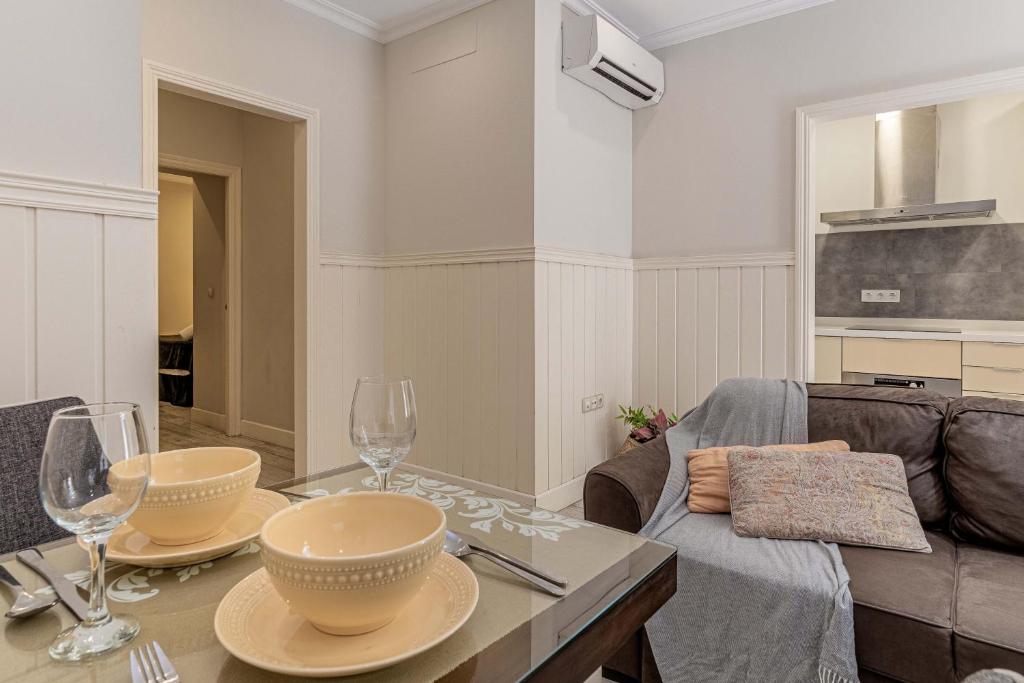 een woonkamer met een tafel met wijnglazen bij Apartamentos Recaredo 7 in Sevilla