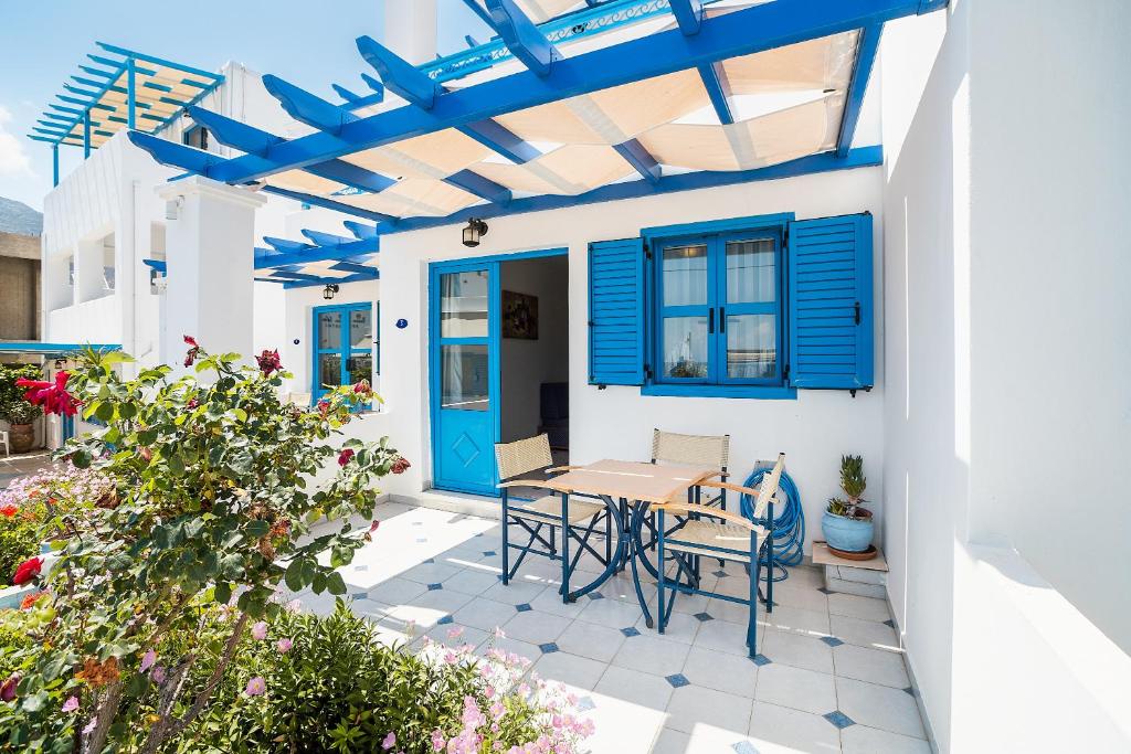 a patio with a table and chairs and a blue door at Livadia Beach Suite in Livadia