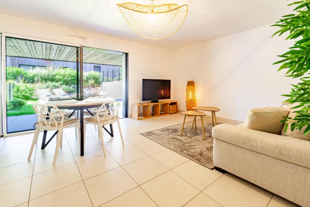 un salon avec une table et un canapé dans l'établissement Viviane - T3 reposant - Jardin - Garage - Wifi, à Vannes