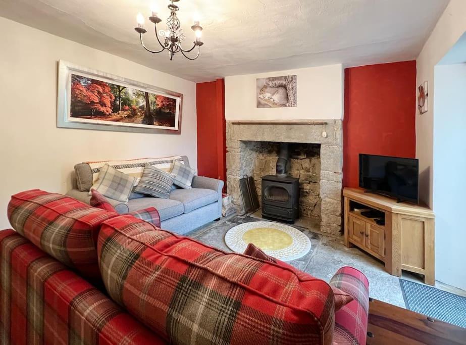 a living room with a couch and a fireplace at Foresters Inn Cottage in Parkend