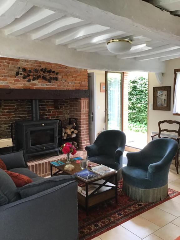 a living room with two chairs and a fireplace at Le Gîte du Vivier in Valmont