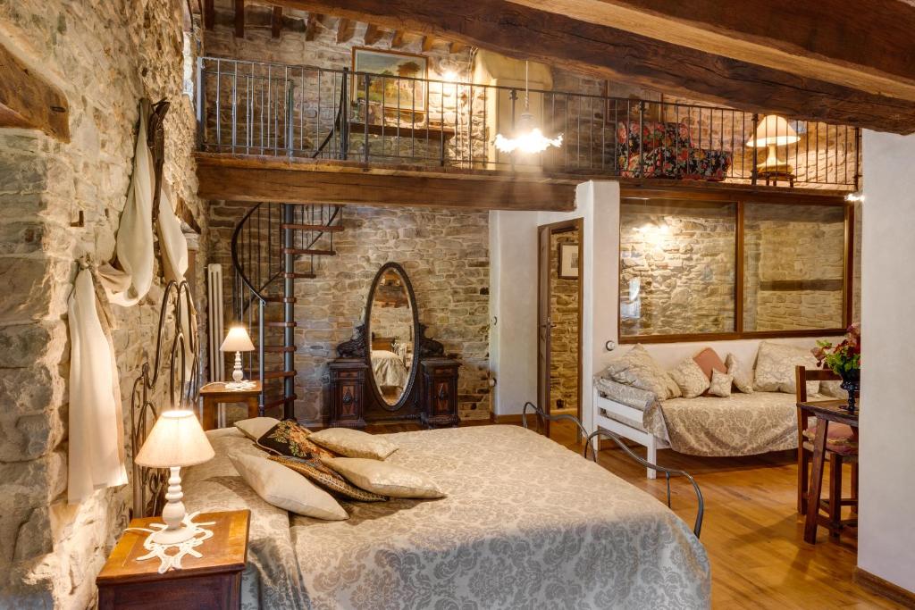 a bedroom with a bed and a stone wall at Agriturismo Biologico Castello Della Pieve in Mercatello sul Metauro