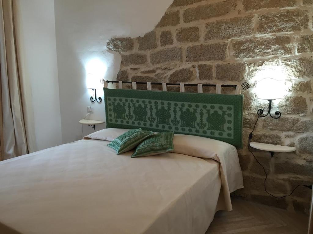 a bedroom with a bed with a stone wall at Appartamento Sasimedda in San Pantaleo