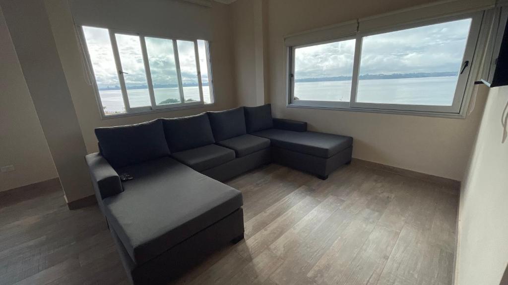 uma sala de estar com um sofá e duas janelas em Edificio Itasu - 3ro - alquileres temporales em Posadas