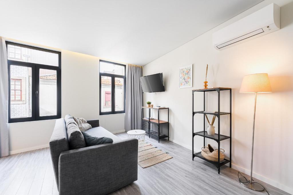un salon avec un canapé et quelques fenêtres dans l'établissement General Torres Apartments, à Vila Nova de Gaia