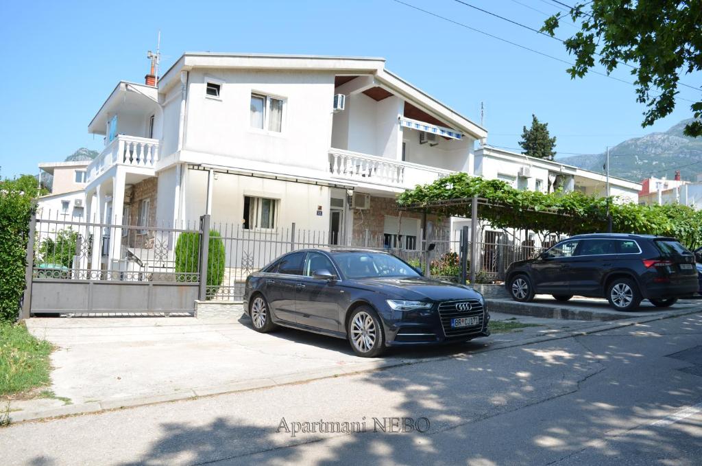 zwei Autos, die vor einem Haus geparkt sind in der Unterkunft Apartmani "Nebo" in Sutomore