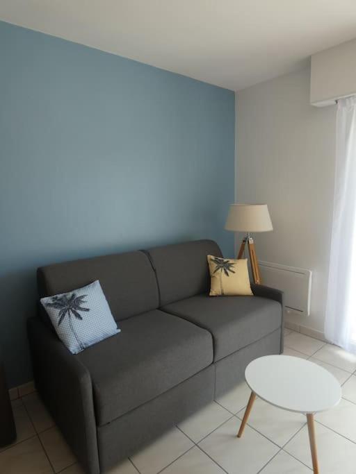un salon avec un canapé et une table dans l'établissement Joli Studio 28m² 200m plage avec balcon, à Saint-Hilaire-de-Riez