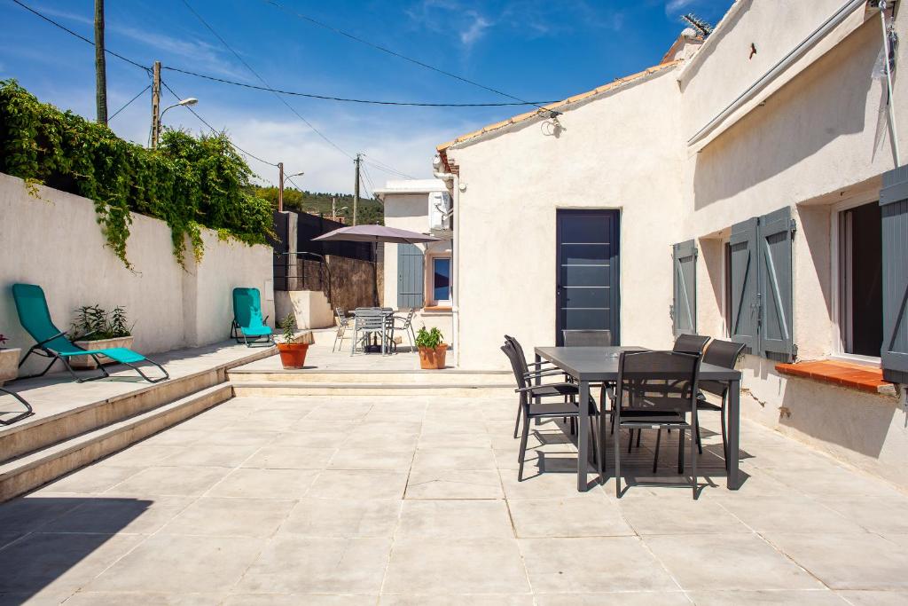 un patio con tavolo e sedie su un edificio di Maison de vacances a La Ciotat
