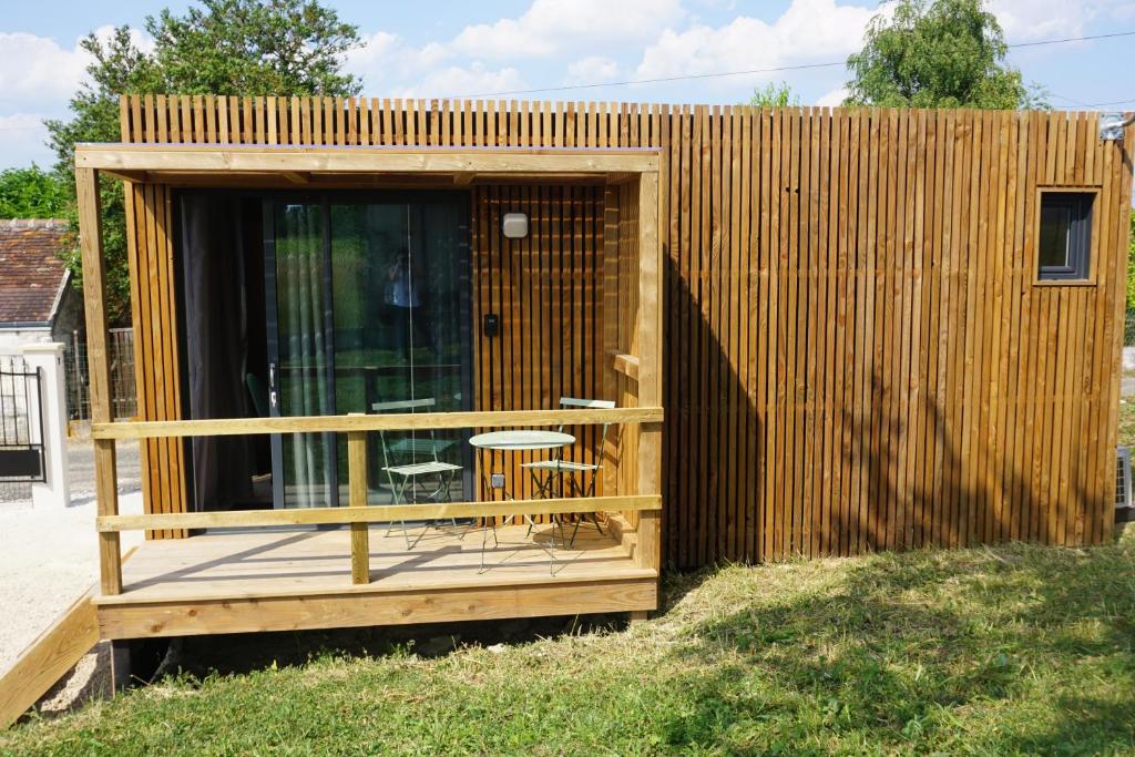 un pequeño cobertizo de madera con una mesa y una silla en Riva Kub, en Saint-Aignan