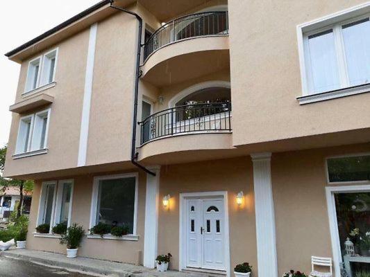 a building with a white door and a balcony at Къща за гости НЕЛ in Chernomorets