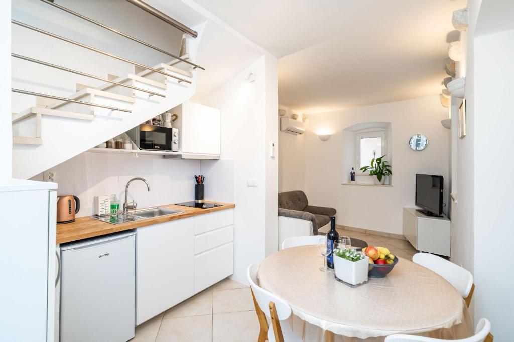 Il comprend une petite cuisine et une salle à manger avec une table et des chaises. dans l'établissement Dubrovnik Gate Apartments, à Dubrovnik