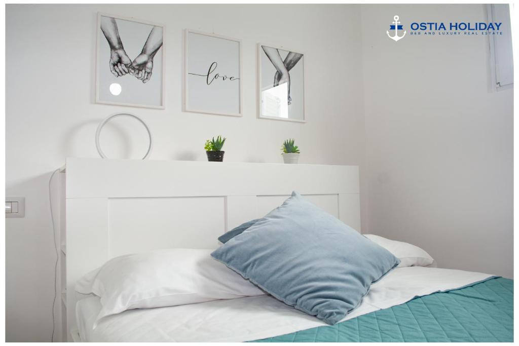 Una cama con una almohada azul encima. en Appartamento Tristano e Isotta, en Lido di Ostia