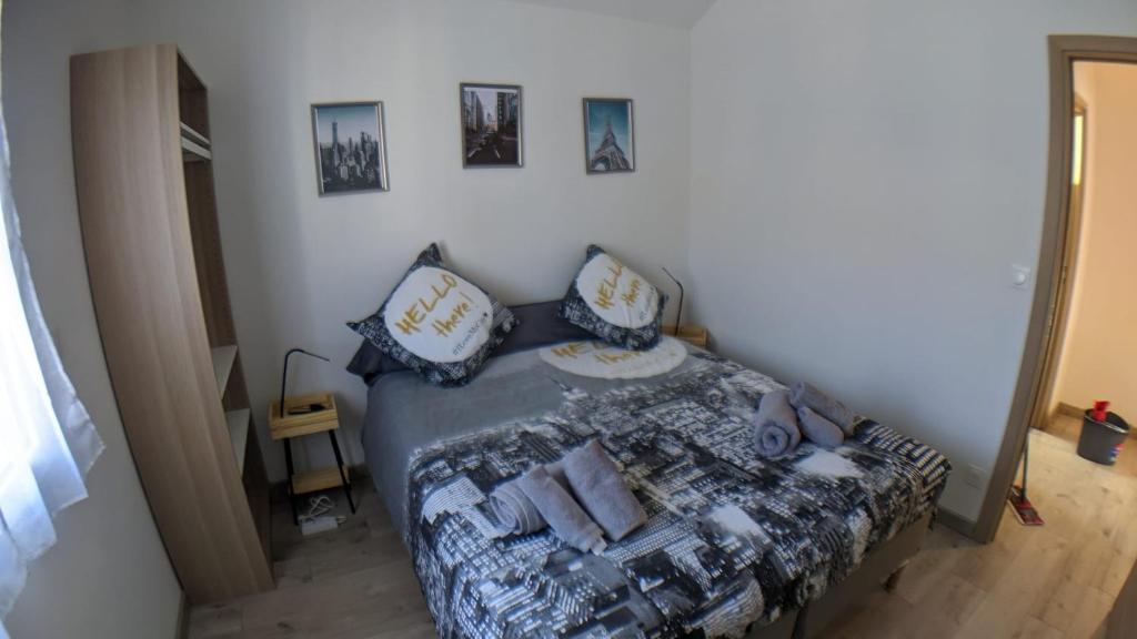 une chambre avec un lit avec des oreillers bleus et blancs dans l'établissement Chambre urbaine dans Maison Moderne, à Dammarie-les-Lys