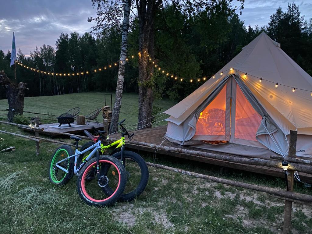 Karula Stay Romantic and Luxurious stay in Karula National Park في Ähijärve: خيمة فيها دراجة متوقفة امامها