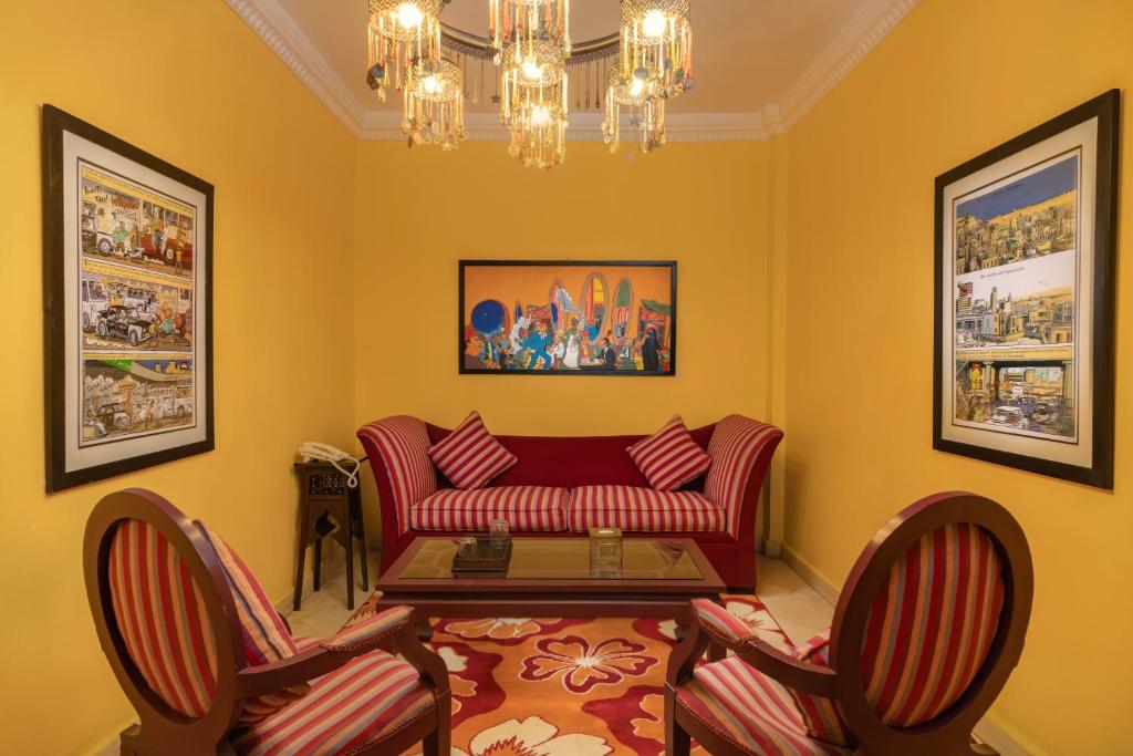 a living room with a red couch and two chairs at Le Riad Hotel de Charme in Cairo