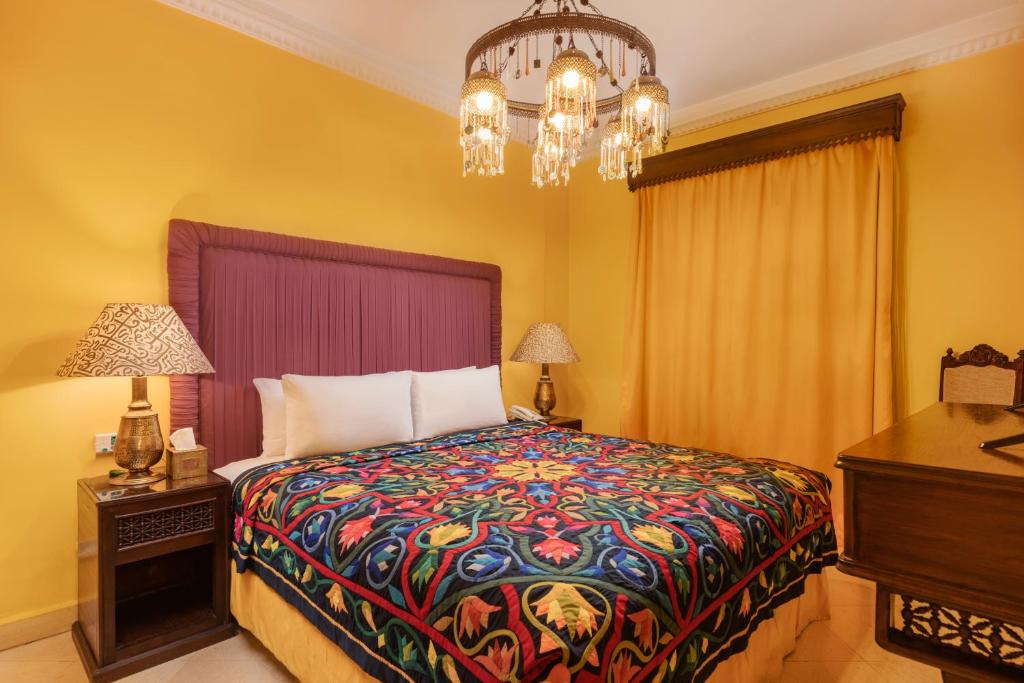 a bedroom with a bed with a colorful blanket at Le Riad Hotel de Charme in Cairo