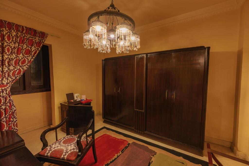 a living room with a large cabinet and a chandelier at Le Riad Hotel de Charme in Cairo
