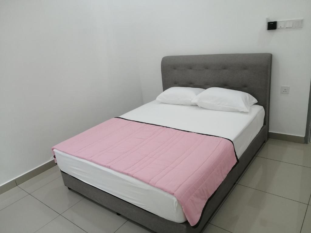 een bed met roze en witte lakens en kussens bij HOMESTAY PD ERA in Port Dickson