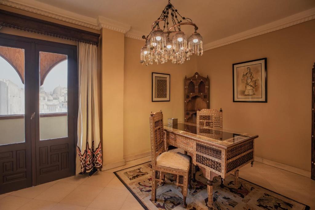 a dining room with a table and a chandelier at Le Riad Hotel de Charme in Cairo