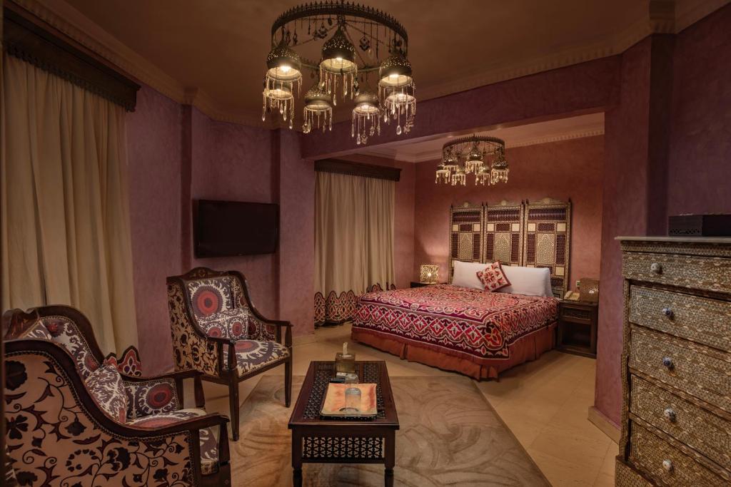 a bedroom with a bed and a chandelier at Le Riad Hotel de Charme in Cairo