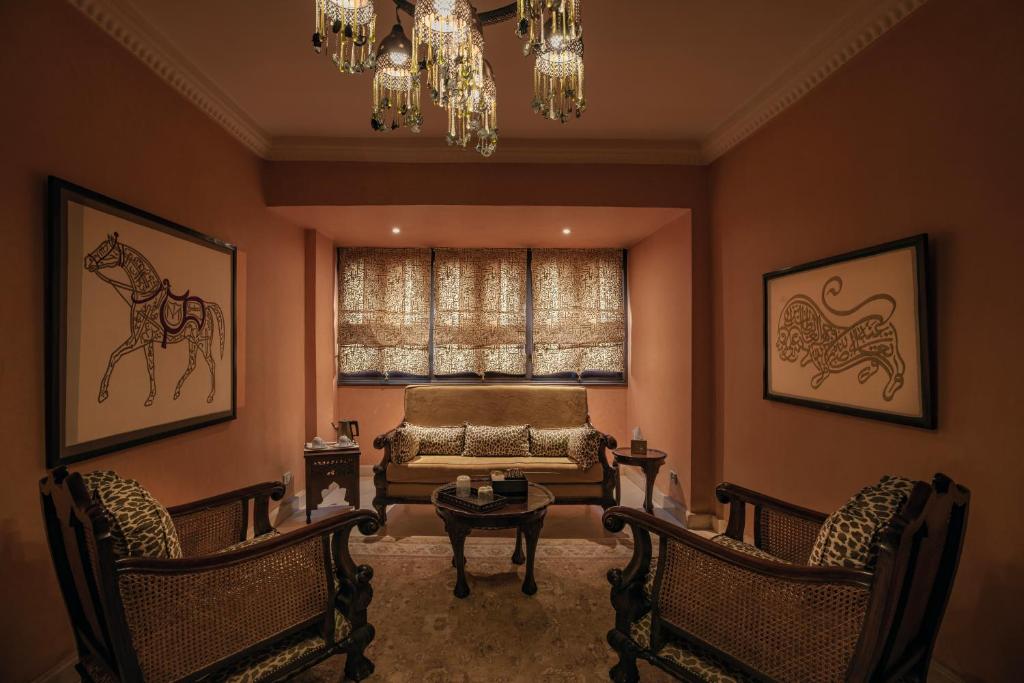 a living room with a couch and chairs and a chandelier at Le Riad Hotel de Charme in Cairo