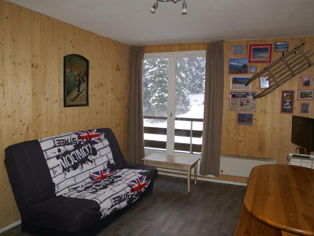 un salon avec un canapé et une fenêtre dans l'établissement 2 pièces au pied des pistes avec balcon et casier à skis - FR-1-557-52, à Les Adrets