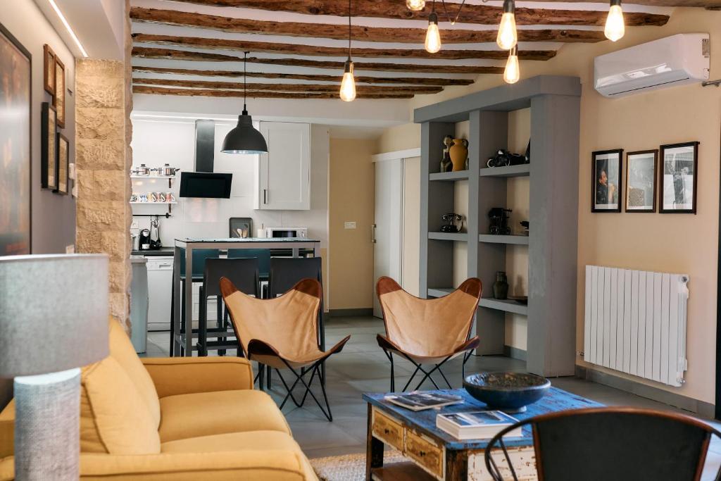 ein Wohnzimmer mit einem Sofa, Stühlen und einem Tisch in der Unterkunft Apartamentos One in Teruel