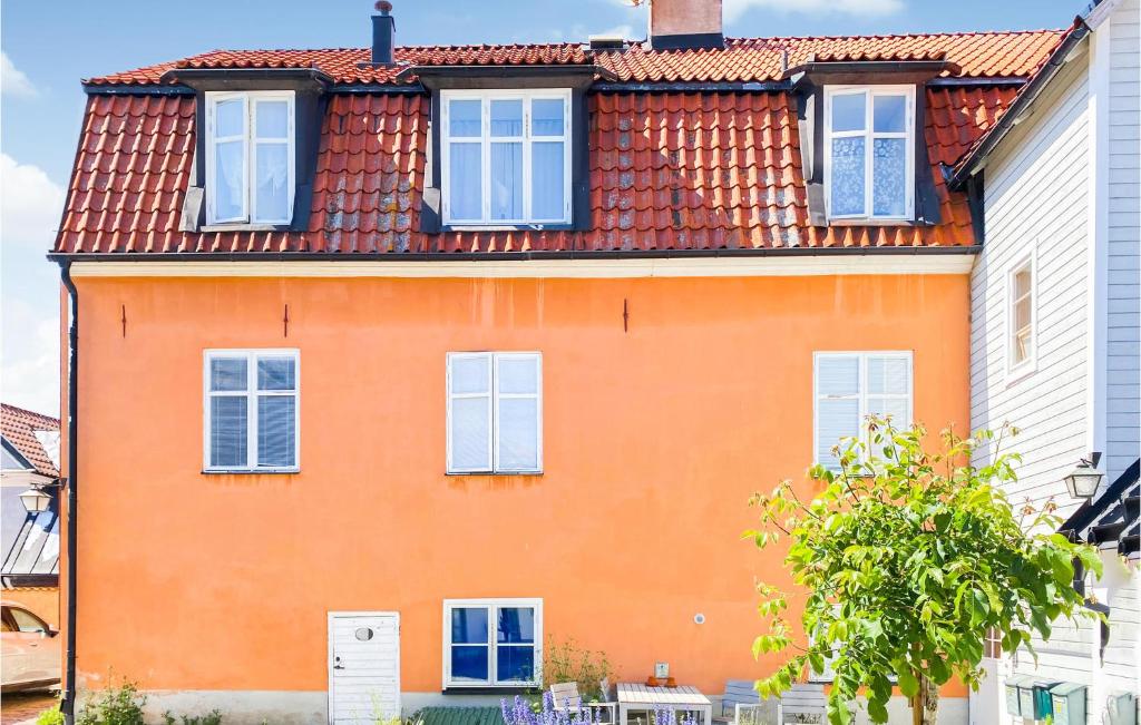 an orange house with white windows and a roof at 3 Bedroom Cozy Apartment In Visby in Visby