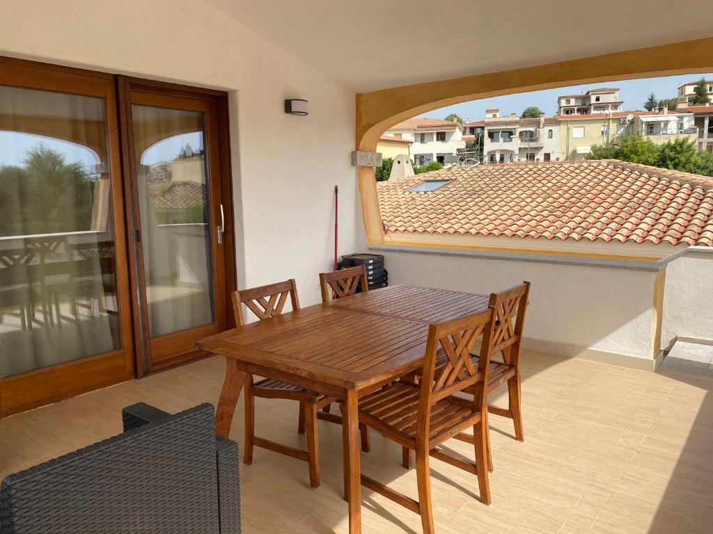 drewniany stół i krzesła w pokoju z balkonem w obiekcie villetta con terrazza w mieście Posada