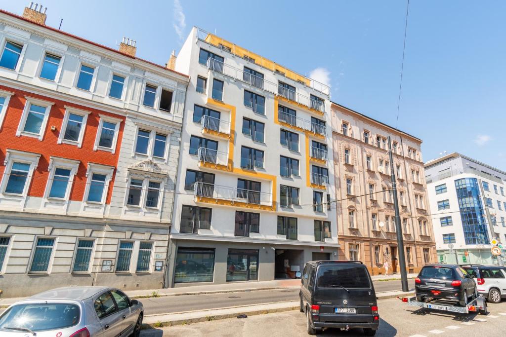 a large white building with cars parked in front of it at Brand new two room apartment #34 with free secure parking in the center in Prague