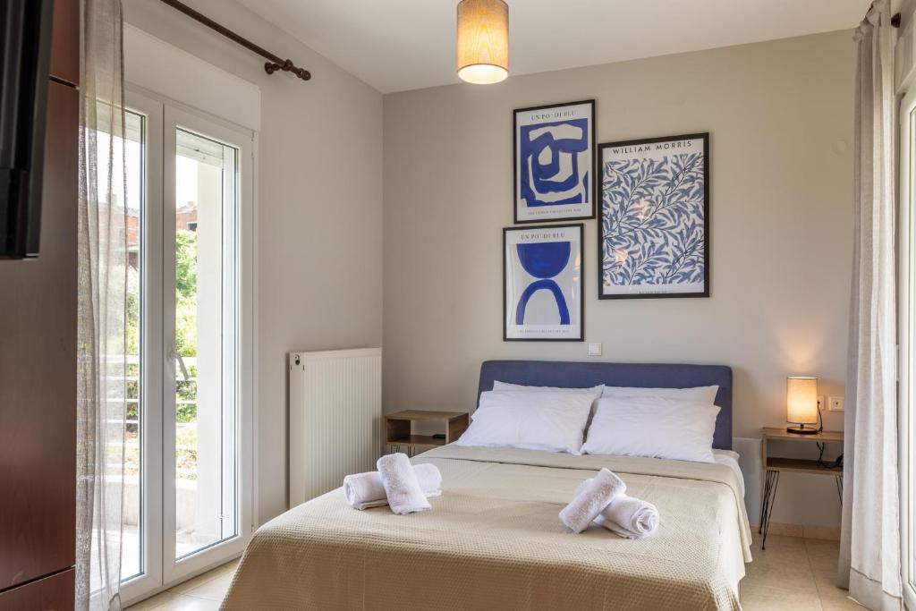 1 dormitorio con 1 cama con toallas en The Olympus Estate, en Litóchoron
