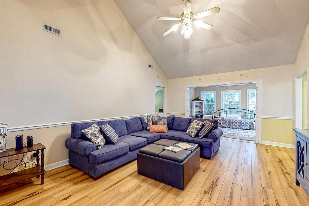 a living room with a blue couch and a ceiling fan at 1990's Classic in North Myrtle Beach