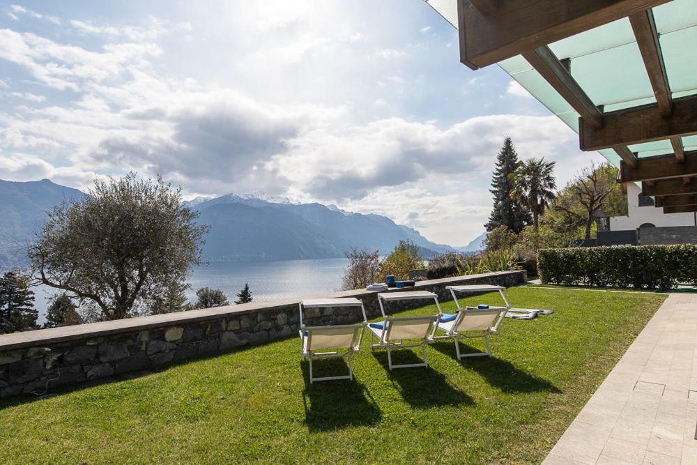 a group of chairs sitting on the grass near the water at Villa Nicolette sleeps 8 in Menaggio
