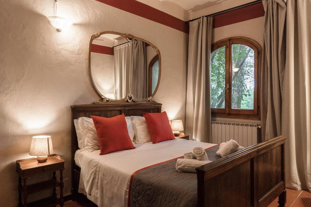 a bedroom with a bed with a mirror on the wall at Borgo Dolciano in Chiusi
